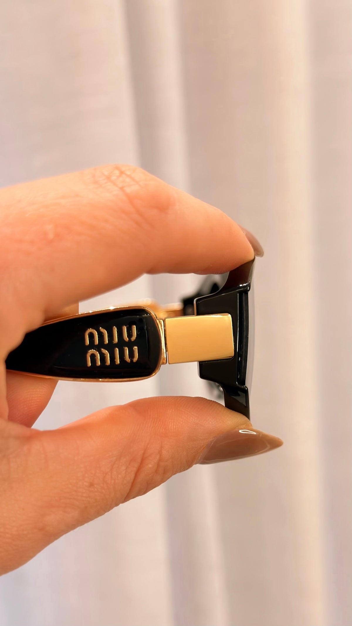 Óculos de Sol Miu Miu Oval Preto com Detalhes Dourados