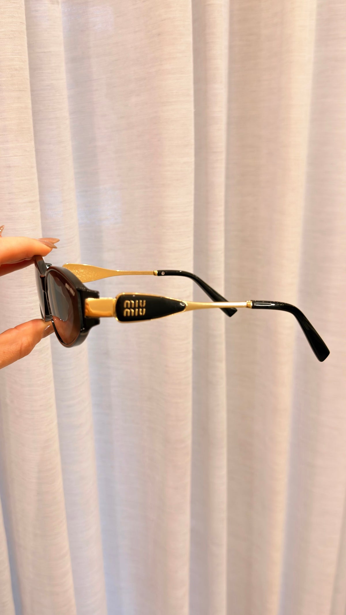 Óculos de Sol Miu Miu Oval Preto com Detalhes Dourados
